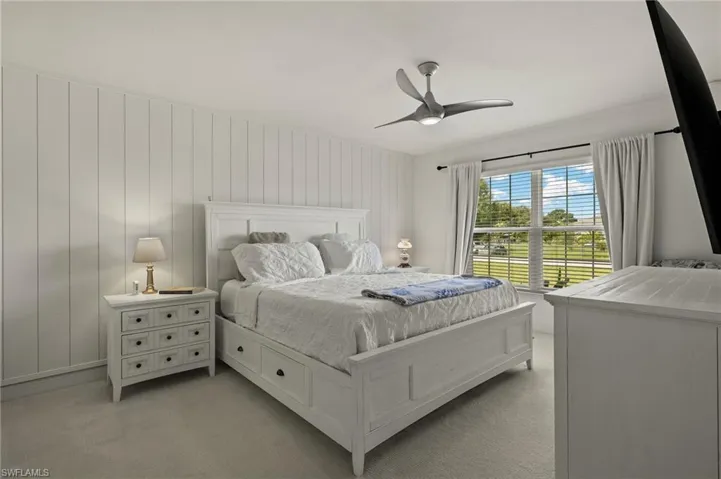 Carpeted bedroom featuring ceiling fan