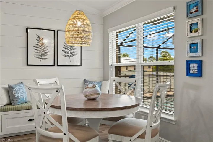 Dining area with crown molding, a chandelier, wood-type flooring, and wooden walls