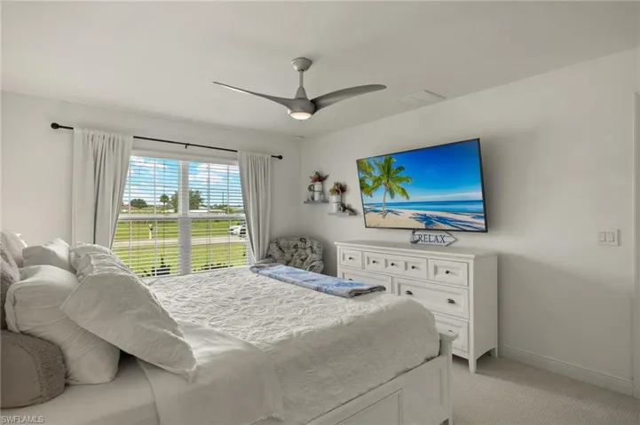Bedroom featuring light colored carpet and ceiling fan