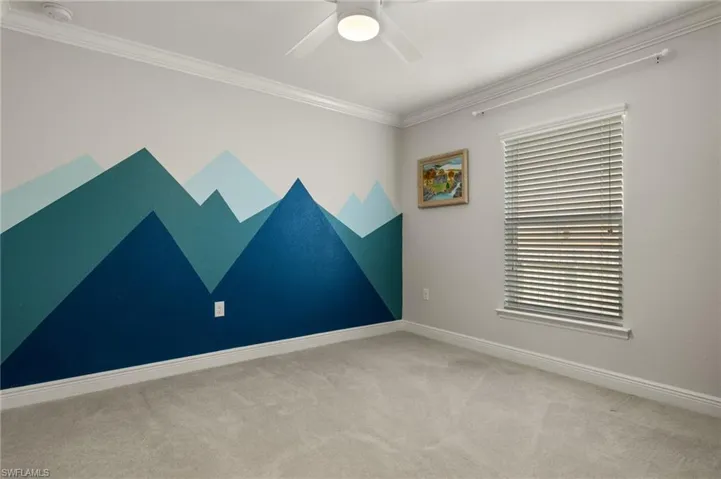 Spare room with crown molding, ceiling fan, and carpet floors
