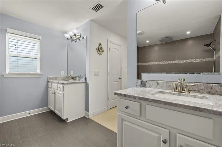 Bathroom featuring vanity and a tile shower