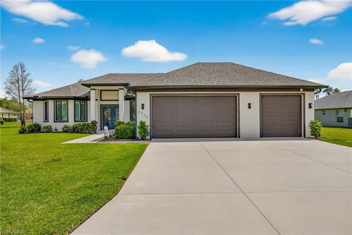 Prairie-style home featuring a front lawn, stucco siding, and an attached garage