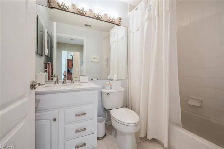 Full bathroom featuring vanity, light tile patterned floors, and shower / tub combo with curtain