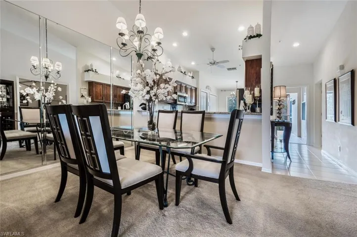 Dining room with a chandelier, light colored carpet, ceiling fan, recessed lighting, and light tile patterned floors