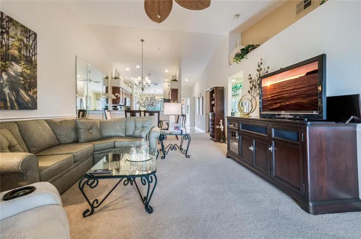 Living area with a chandelier, light colored carpet, a ceiling fan, and recessed lighting