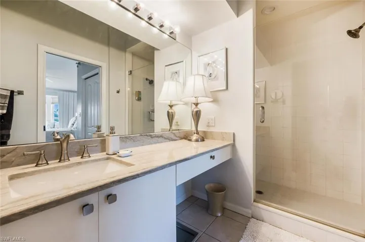 Full bathroom featuring vanity, a stall shower, and light tile patterned floors