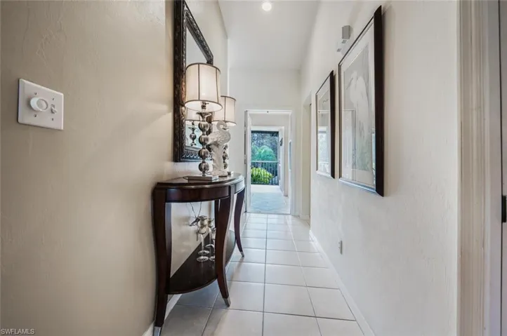 Hall with a textured wall and light tile patterned flooring
