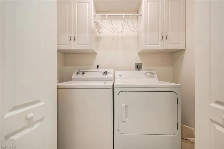 Washroom featuring washing machine and clothes dryer and cabinet space