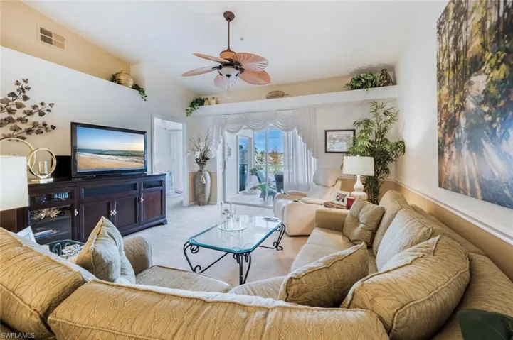 Living area with vaulted ceiling, carpet, and ceiling fan