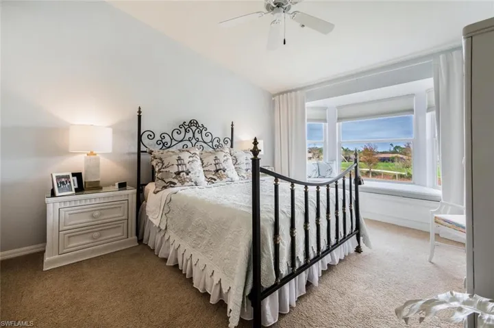 Carpeted bedroom with ceiling fan and baseboards