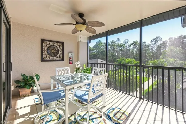 Sunroom / solarium with a ceiling fan and outdoor dining area