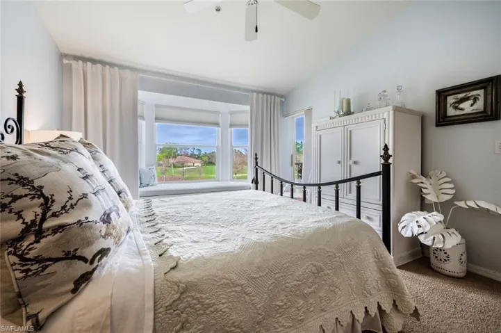 Carpeted bedroom with lofted ceiling and a ceiling fan