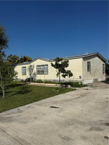 Manufactured / mobile home featuring a front yard and concrete driveway