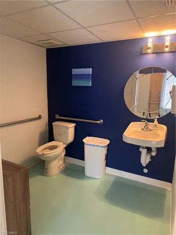 Bathroom with concrete floors and a drop ceiling
