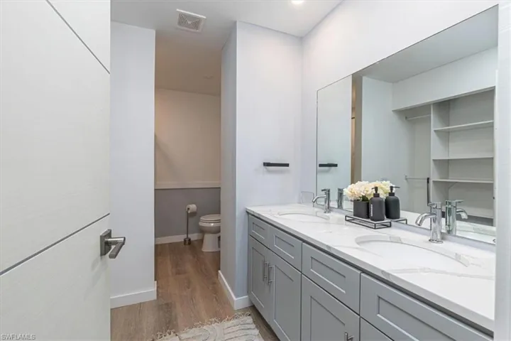 Bathroom with double vanity and light wood finished floors