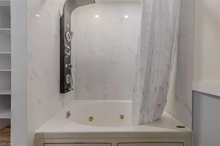 Full bathroom with a combined bath / shower with jetted tub