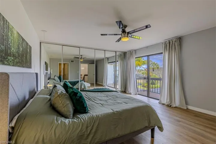Bedroom with access to exterior, wood finished floors, and ceiling fan