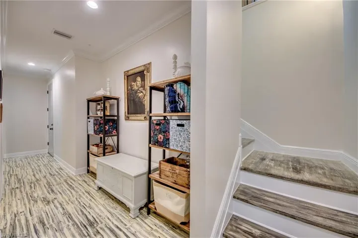 Stairs featuring light hardwood / wood-style flooring and crown molding