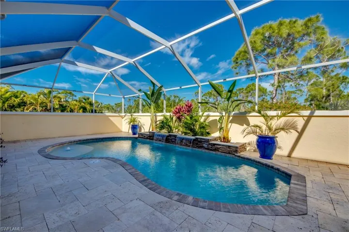 View of swimming pool featuring pool water feature, a patio, and a lanai