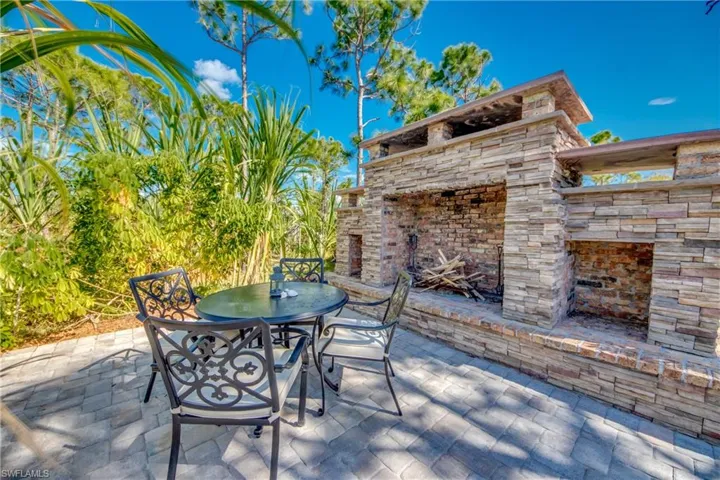 View of patio / terrace featuring an outdoor stone fireplace