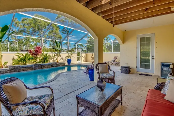 View of swimming pool featuring a patio area, pool water feature, and glass enclosure