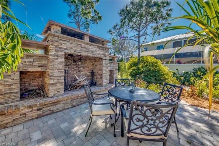 View of patio with an outdoor stone fireplace
