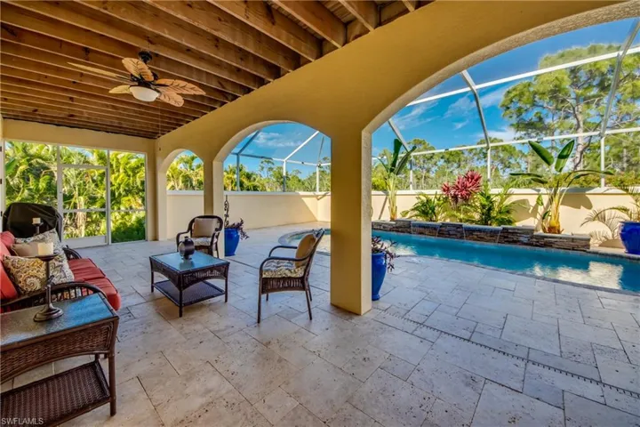 View of swimming pool featuring pool water feature, a patio, a lanai, and ceiling fan