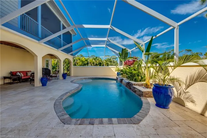 View of swimming pool with a patio, pool water feature, and glass enclosure