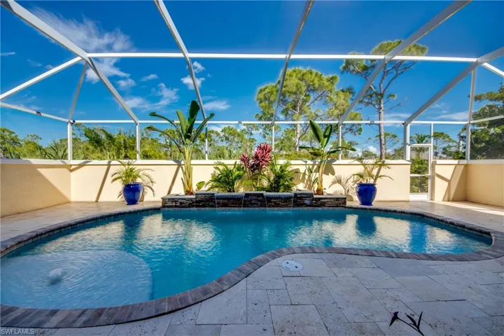View of swimming pool with pool water feature, a patio, and a lanai