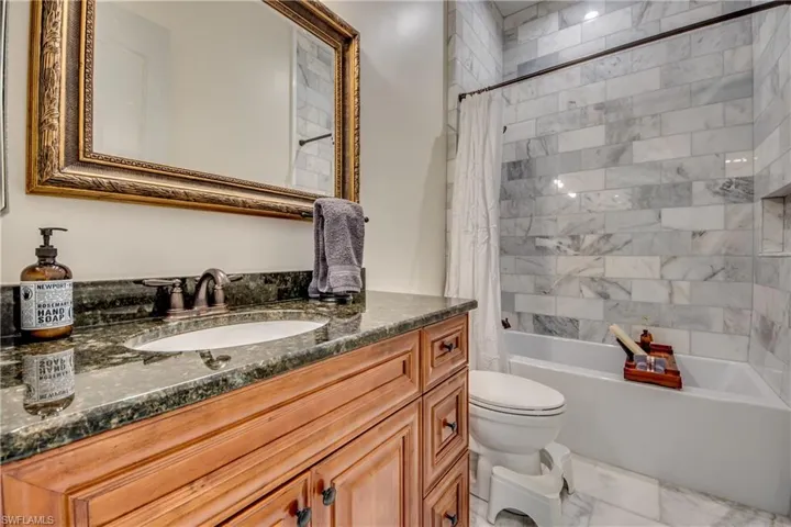 Full bathroom featuring vanity, shower / bath combo, toilet, and tile patterned flooring