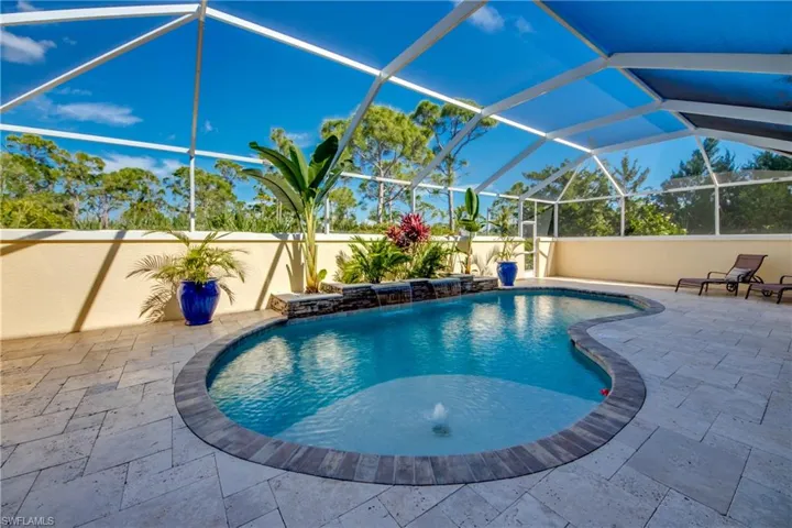 View of swimming pool with pool water feature, a patio area, and a lanai