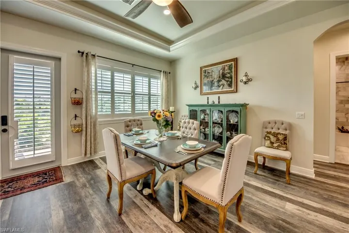 Dining area featuring a tray ceiling, ceiling fan, and hardwood / wood-style floors