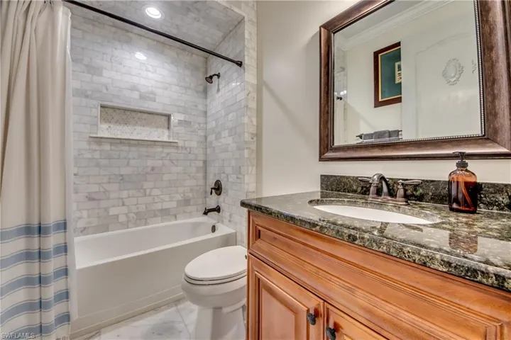 Full bathroom with vanity, toilet, tile patterned floors, and shower / bathtub combination with curtain