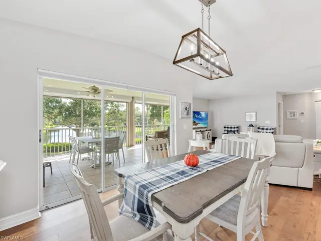 Dining room featuring ceiling fan with notable chandelier and light wood-type flooring