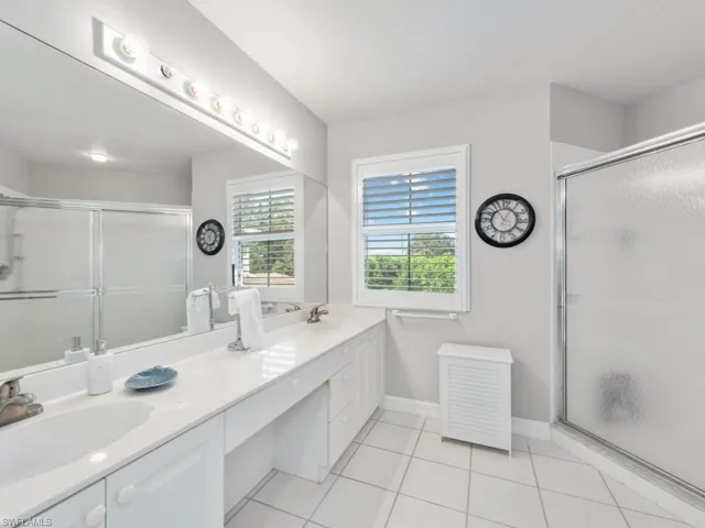 Bathroom with vanity, tile patterned floors, and an enclosed shower