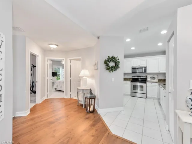 Kitchen with appliances with stainless steel finishes, light wood-type flooring, and white cabinets