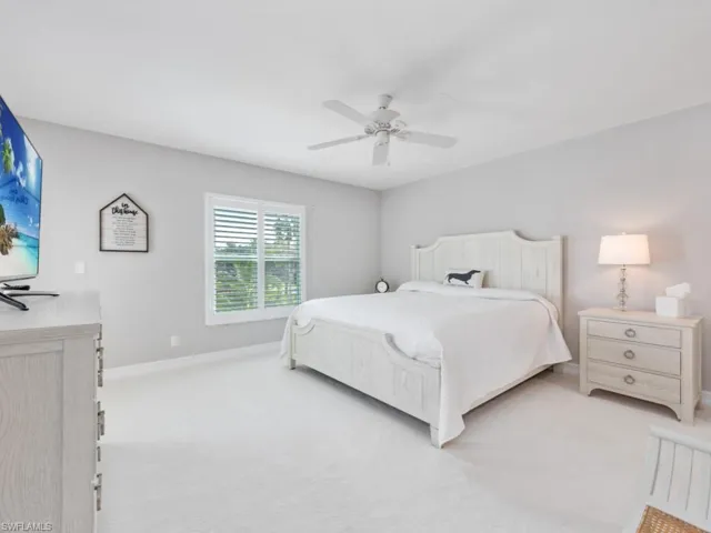 Carpeted bedroom featuring ceiling fan
