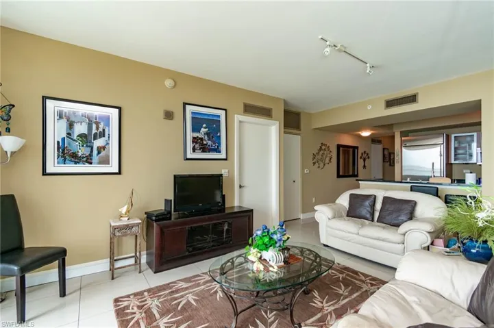 Living room with track lighting and light tile floors