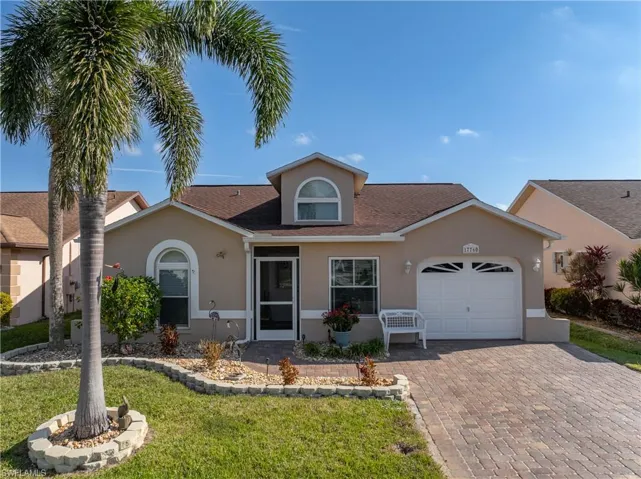 View of front of house featuring a garage and a front lawn