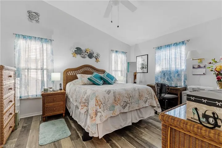 Bedroom featuring lofted ceiling, wood-type flooring, and ceiling fan