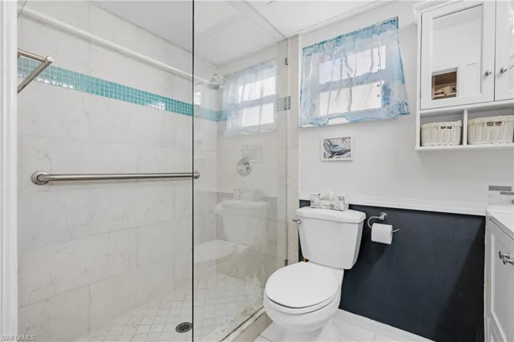 Bathroom featuring toilet, vanity, and walk in shower