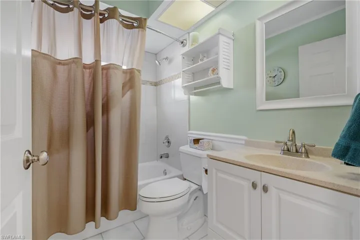 Full bathroom featuring vanity, tile patterned flooring, toilet, and shower / tub combo with curtain
