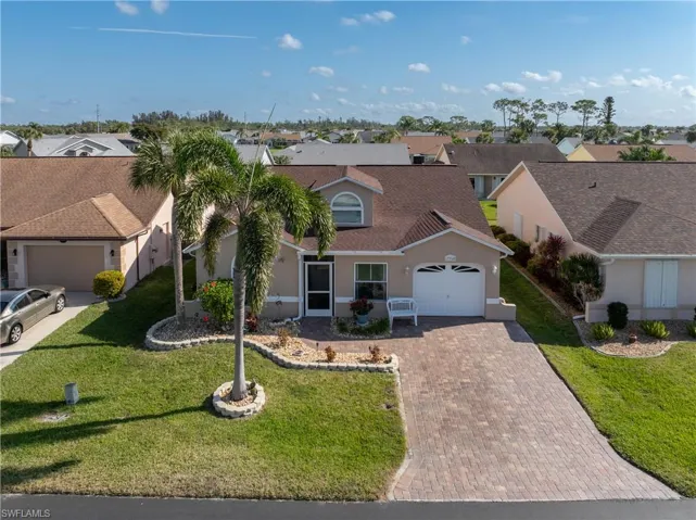 View of front of home with a garage and a front yard