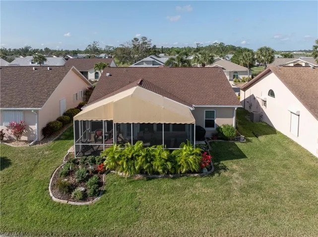Back of house with a lawn, a sunroom, and central air condition unit
