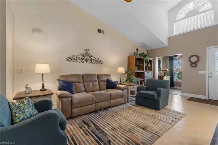 Tiled living room with high vaulted ceiling