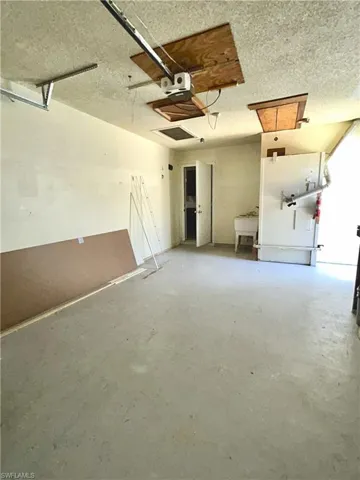 Garage with pull down attic ladder for access  and brand new, utility sink and brand new side man door