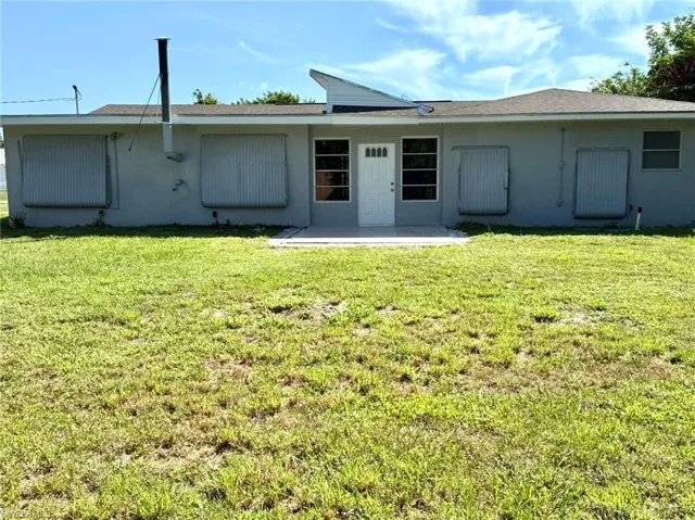 Rear of home with clamshell hurricane shutters in closed position