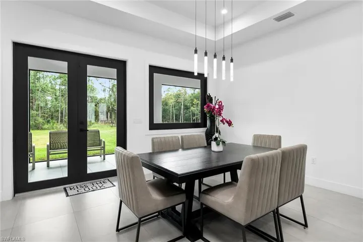 Dining room featuring recessed lighting, light tile patterned flooring, and a tray ceiling