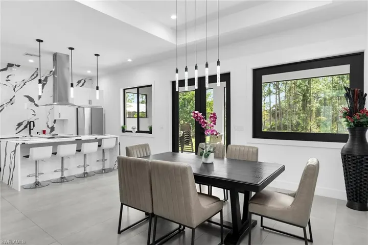 Dining room with light tile patterned flooring, recessed lighting, and a raised ceiling