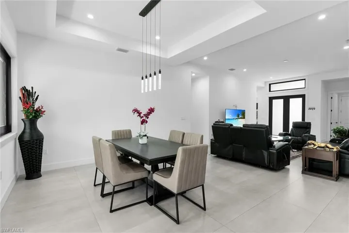 Dining area featuring a raised ceiling, recessed lighting, and light tile patterned floors